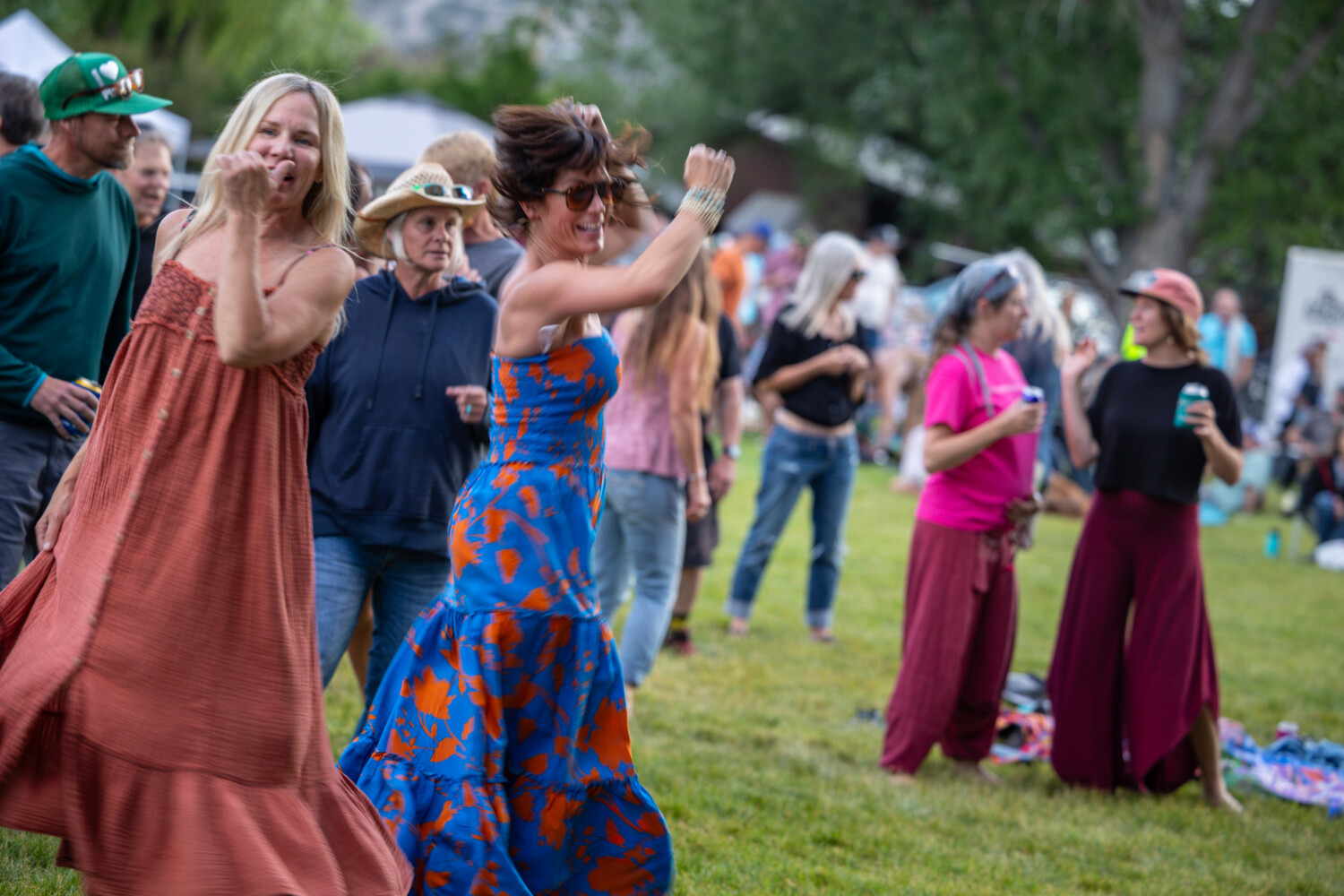 A group of people dancing, two women twirling in dresses during a summer ShowDown Town performance.